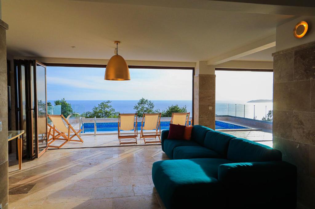 a living room with a couch and a view of a pool at Villa Horus in Sveti Stefan
