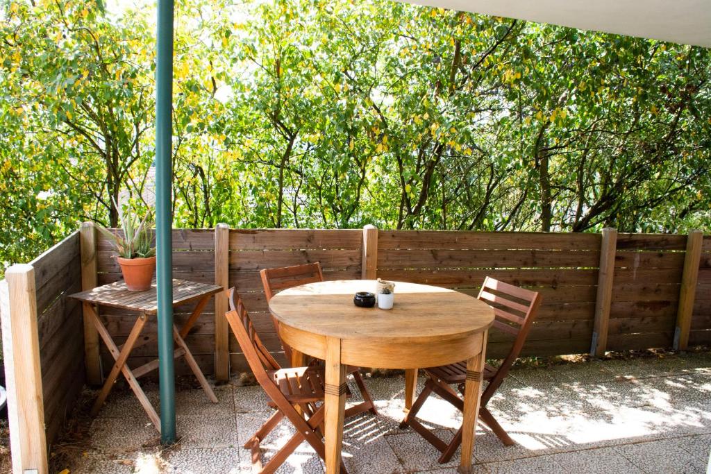 einen Holztisch mit Stühlen und einem Sonnenschirm auf einer Terrasse in der Unterkunft Gemütliches Apartment mit Fernblick auf die Stadt! in Trier
