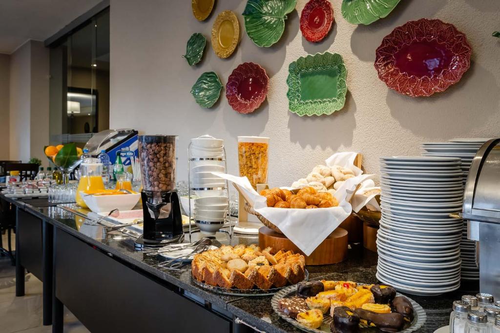 un buffet composé de nourriture, d'assiettes et de boissons dans l'établissement Hotel D. Luis - Elvas, à Elvas