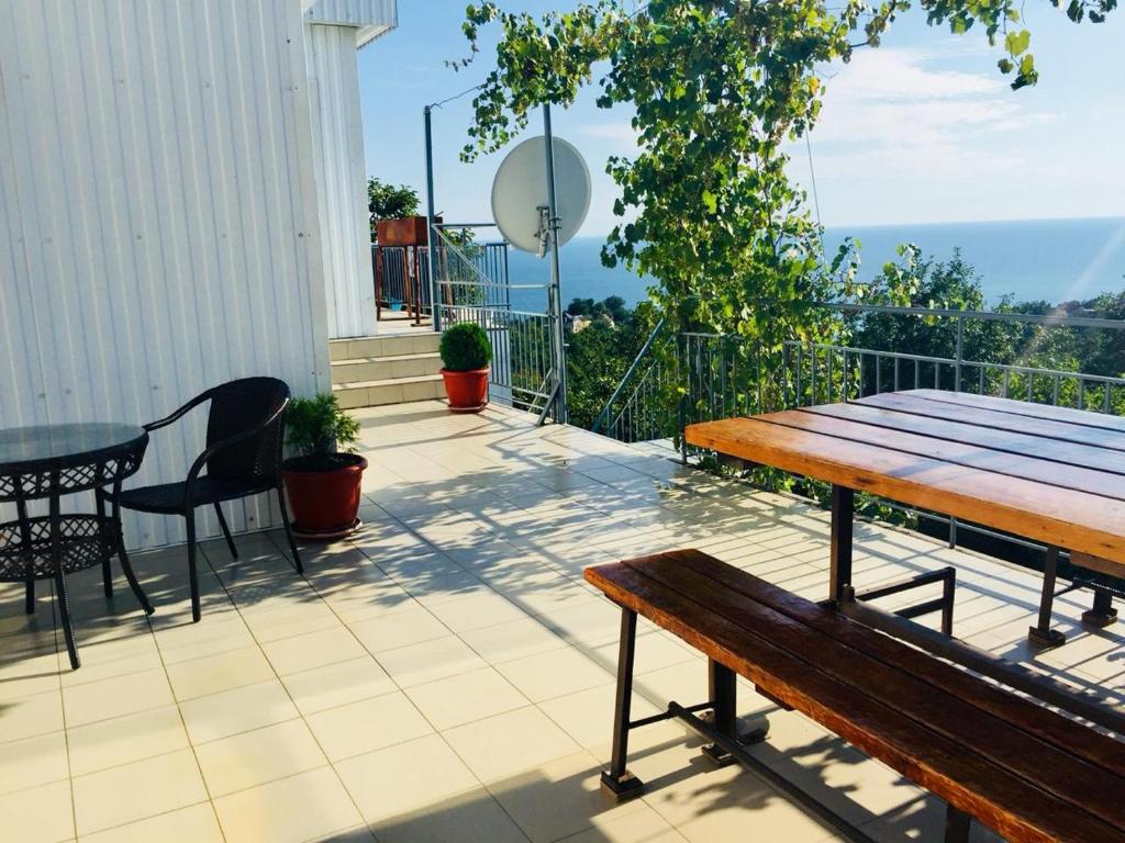 balcón con mesa de madera, mesa y sillas en Chaika Guest House en Tuapse