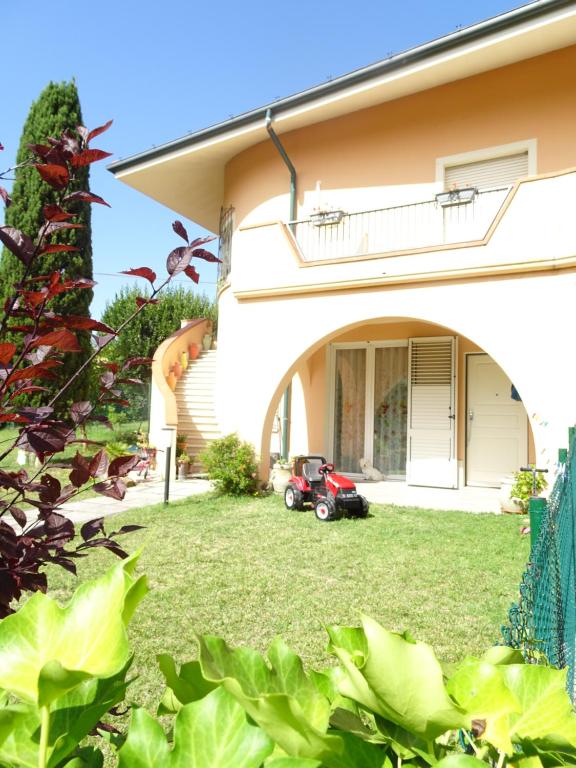 un jardín con una cortadora de césped frente a una casa en Italy Home en San Costanzo