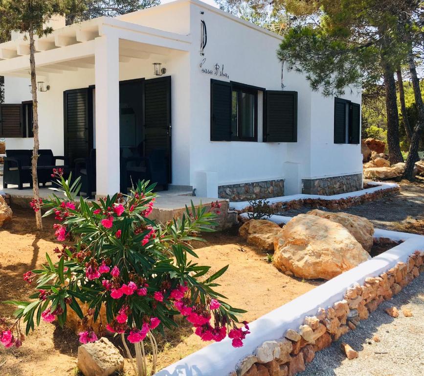 una casa con flores rosas delante de ella en CASA RIBAS en Santa Eulalia del Río