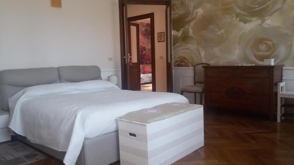 ein Schlafzimmer mit einem weißen Bett und einer Kommode in der Unterkunft Casa Zara in Turin