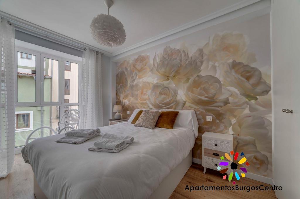 - une chambre avec un lit orné d'une peinture murale dans l'établissement Edificio Aptos Turisticos - Burgos Centro HC7, à Burgos