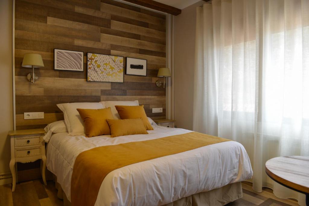 1 dormitorio con 1 cama grande con almohadas amarillas en La casita de El Cuervo en El Cuervo