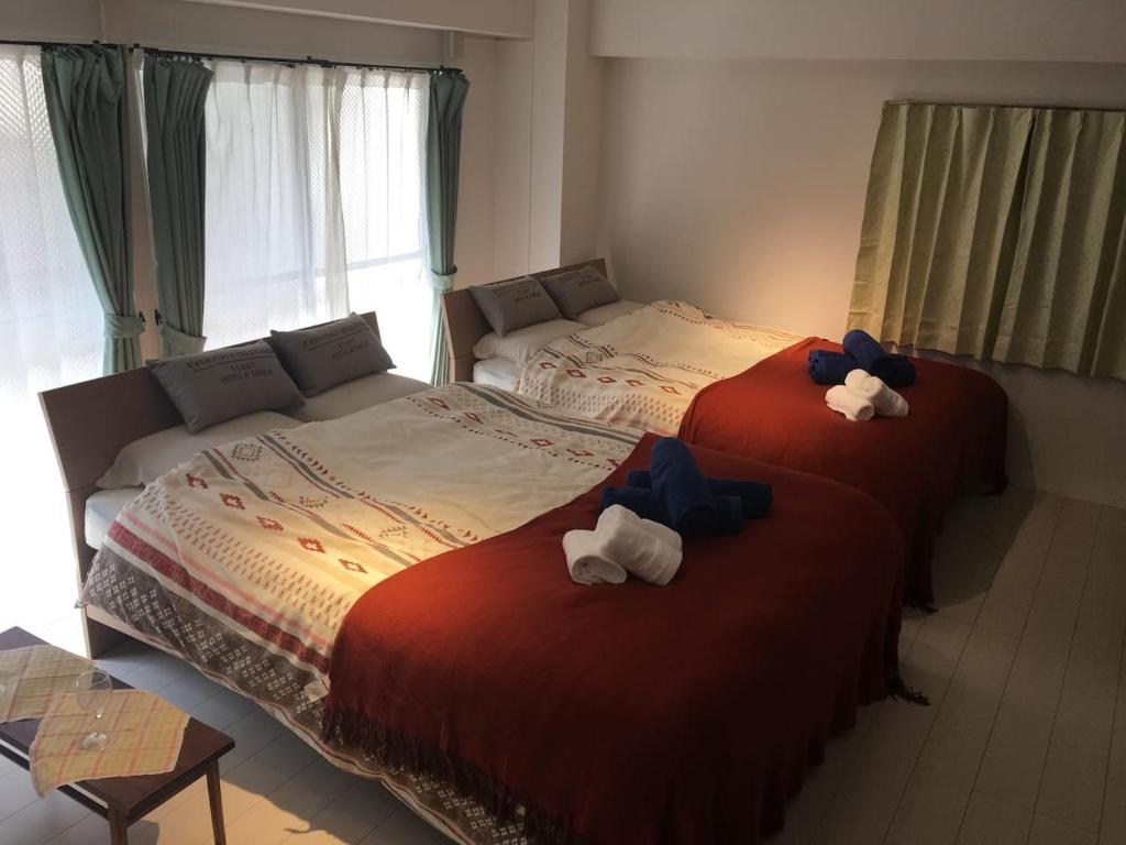 two beds with stuffed animals on them in a bedroom at G&R House 102 in Tokyo