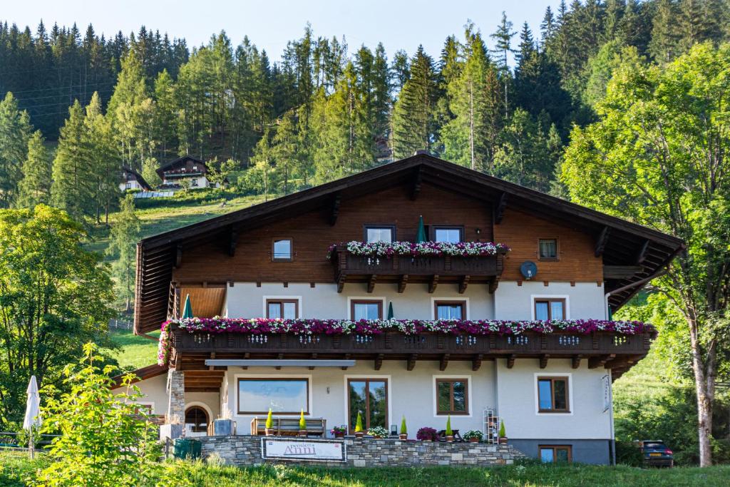 a house in the mountains with flowers on the balcony at Pension Anni in Wagrain