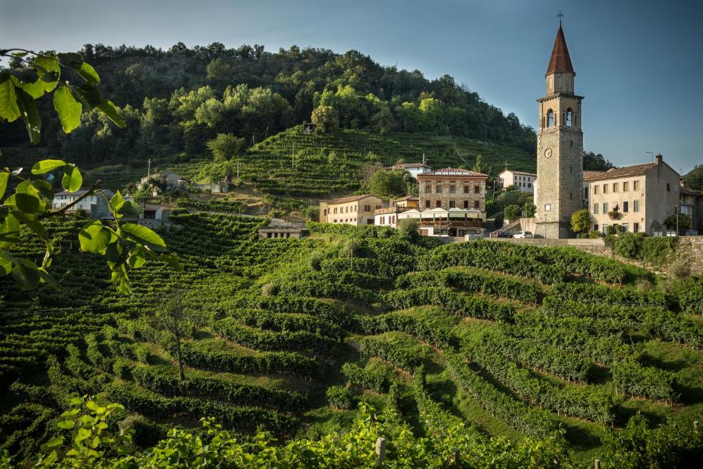a village on a hill with a clock tower at B&B Gastaldo di Rolle in Cison di Valmarino