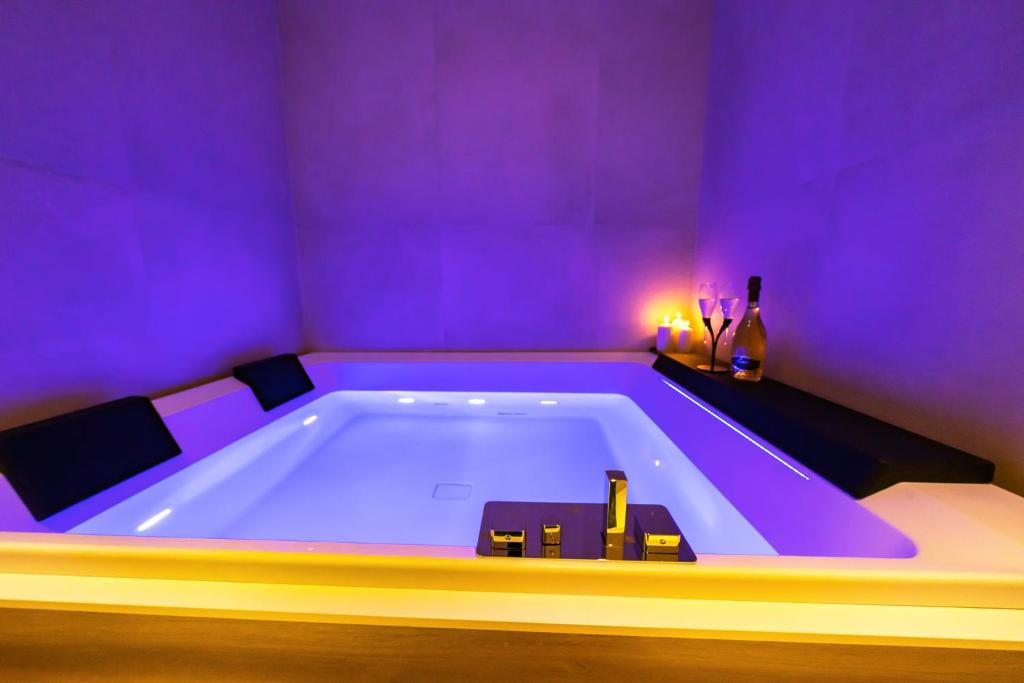a large bath tub in a room with a purple room at Elite Accommodations & Hydromassage Pool in Reggio di Calabria