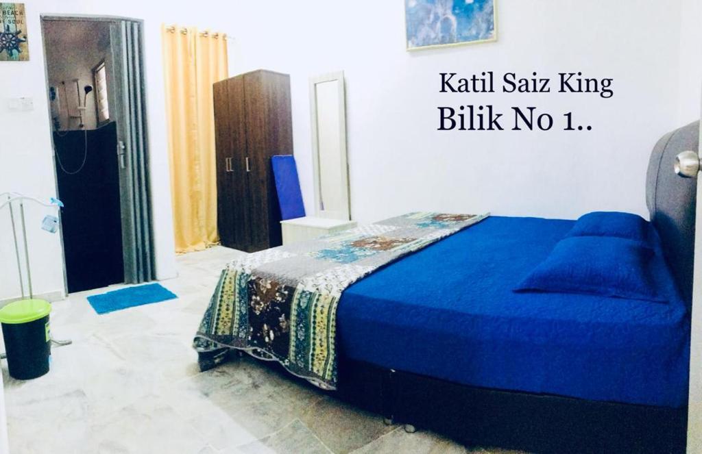 a bedroom with a blue bed with a blue blanket at Pinggiran Homestay in Batu Caves