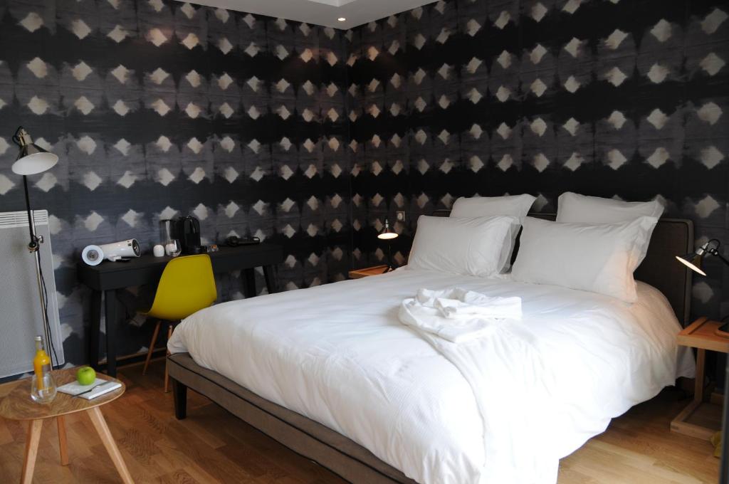 a bedroom with a bed with a black and white wall at Hôtel-Restaurant L'Aquarelle in Breuillet