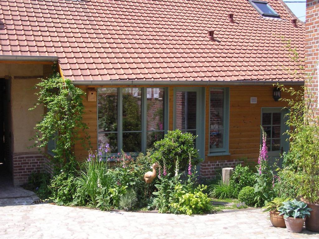 a house with a garden with flowers in front of it at Gîte des Hortillonnages in Camon