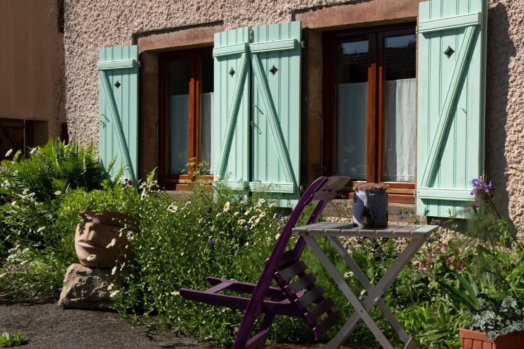 a purple chair sitting in front of a window at Gîte Chez Dimanche in Essert