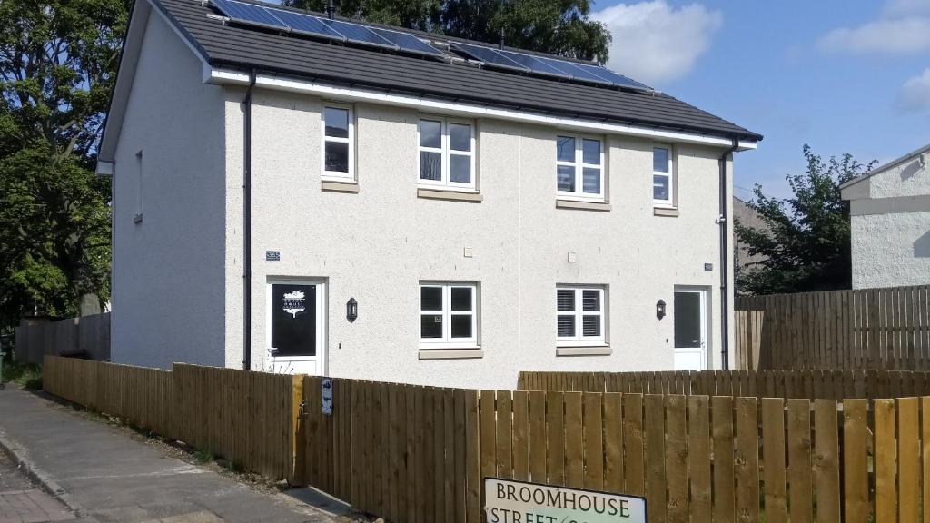 een wit huis met zonnepanelen erop bij BroomHouse HomeStay in Edinburgh