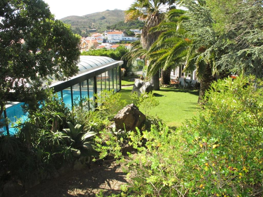 a garden with palm trees and a swimming pool at Morada Sol - Holiday Villas in Cascais in Cascais