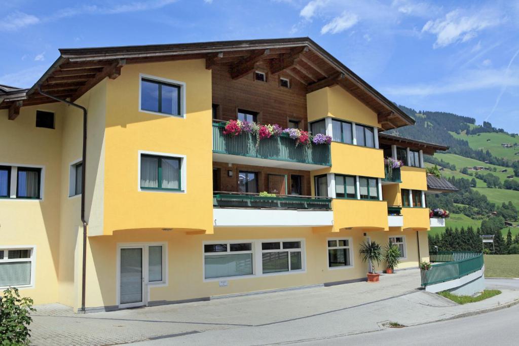 a yellow building with flowers on the balconies at Appartement Pöll Kathrin in Westendorf