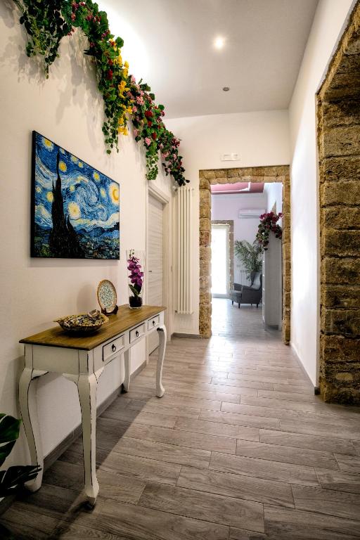 a hallway with a table and a painting on the wall at GARDEN HOUSE: APARTMENTS AND ROOMS FOR HOLIDAYS in Palermo