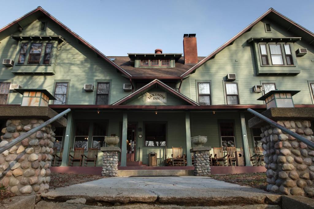 a large green house with a stone wall at Lakeside Inn in Lakeside