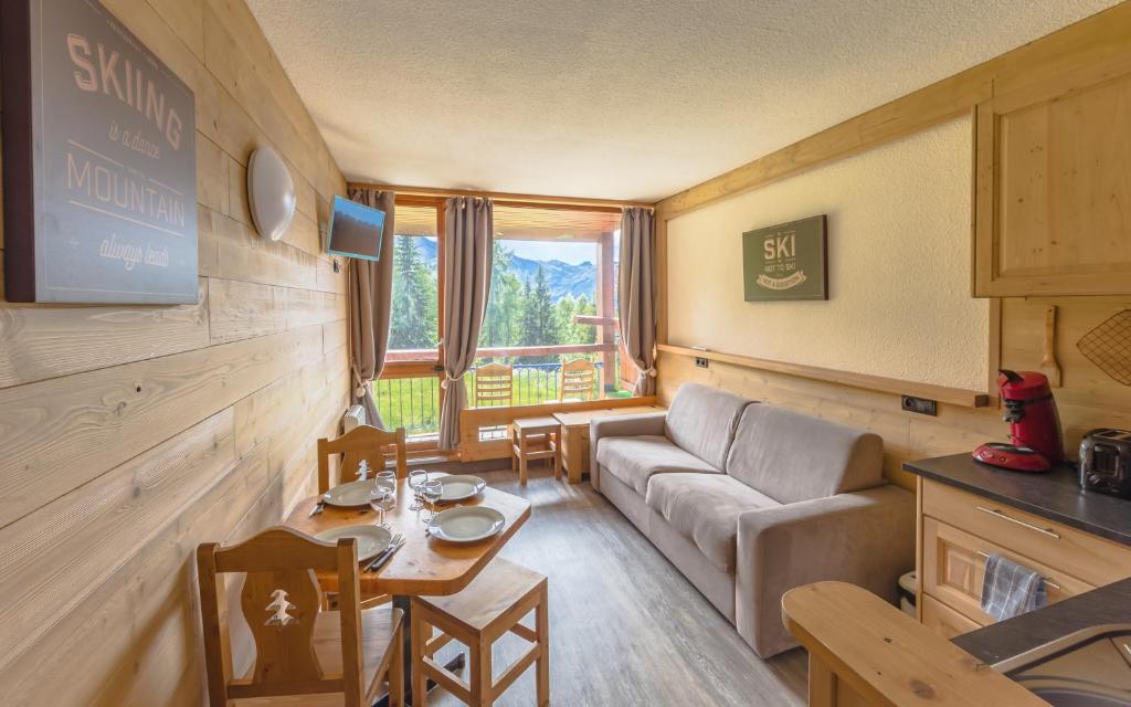 a living room with a couch and a table at Grand Arbois, les Arcs 1800 in Arc 1800