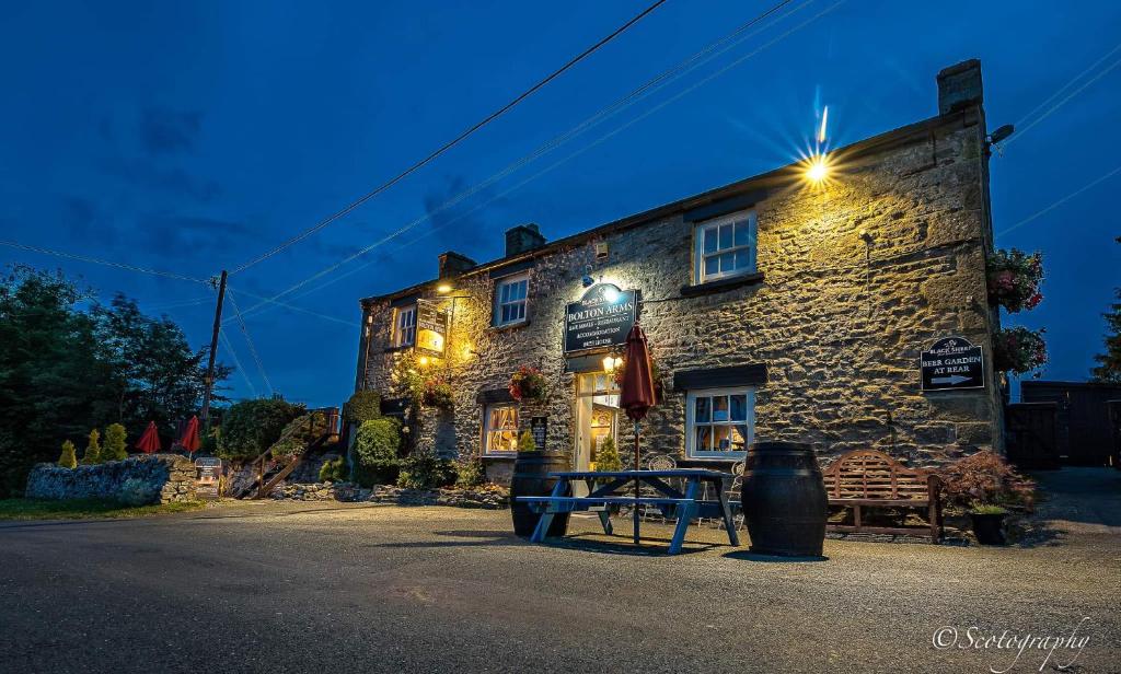 um edifício de pedra com um banco à frente em Bolton arms downholme em Richmond