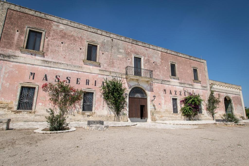 Masseria Mazzetta Salento Corte del Falconiere B&B في سان بانكرازيو سالنتينو: مبنى من الطوب القديم باسم ديره