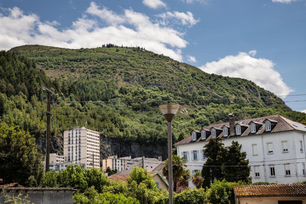 een groene heuvel op de achtergrond van een stad bij T2 parking nice view in Lourdes