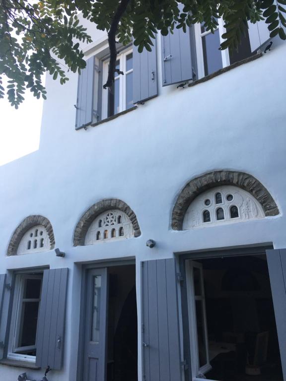 a white building with windows and a door at Tina & Miltos in Kariá