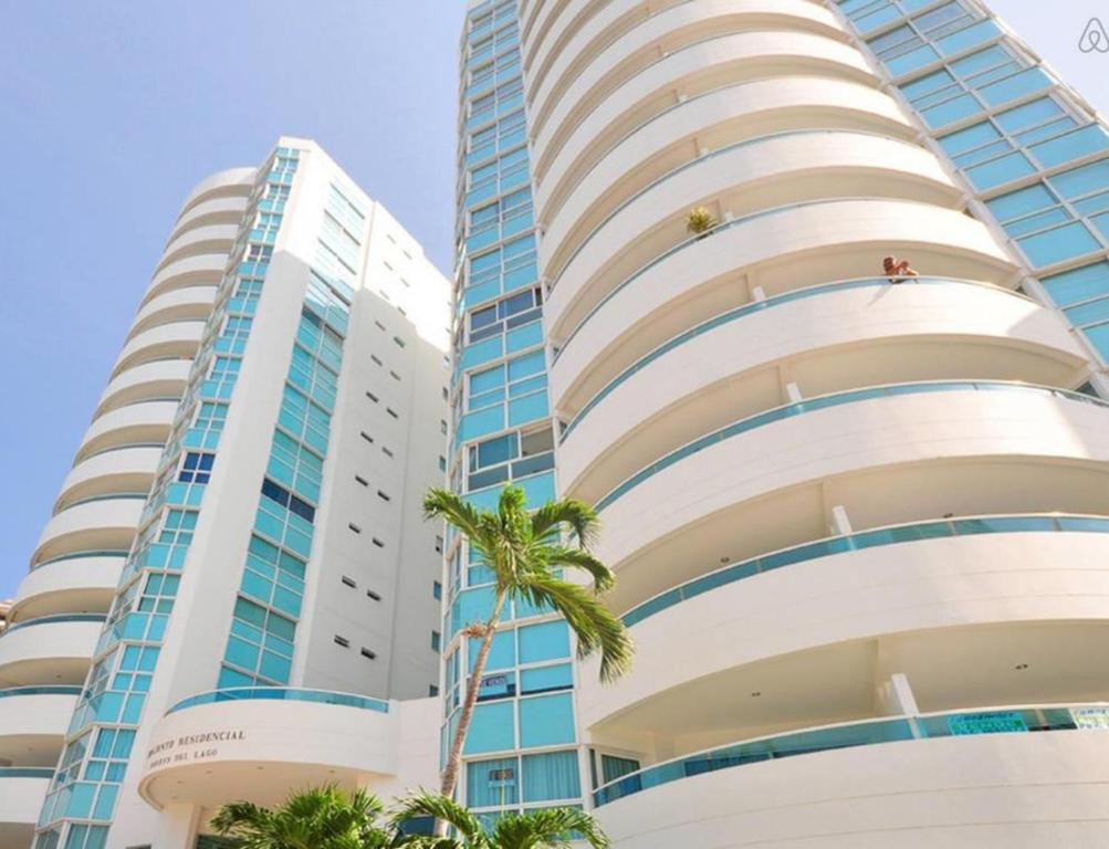 zwei hohe Gebäude mit Palmen davor in der Unterkunft Apartamento con Piscina Cartagena en el Laguito Bocagrande in Cartagena de Indias