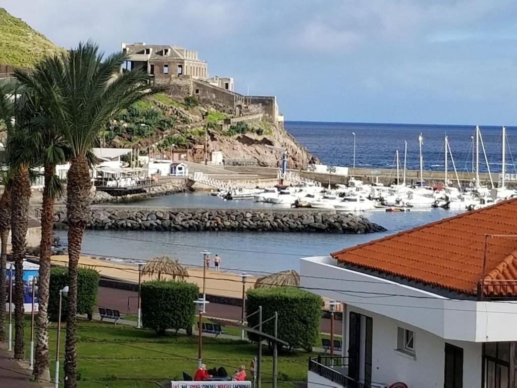 un puerto deportivo con barcos en el agua y un edificio en VIP Paradise Apartment, en Machico