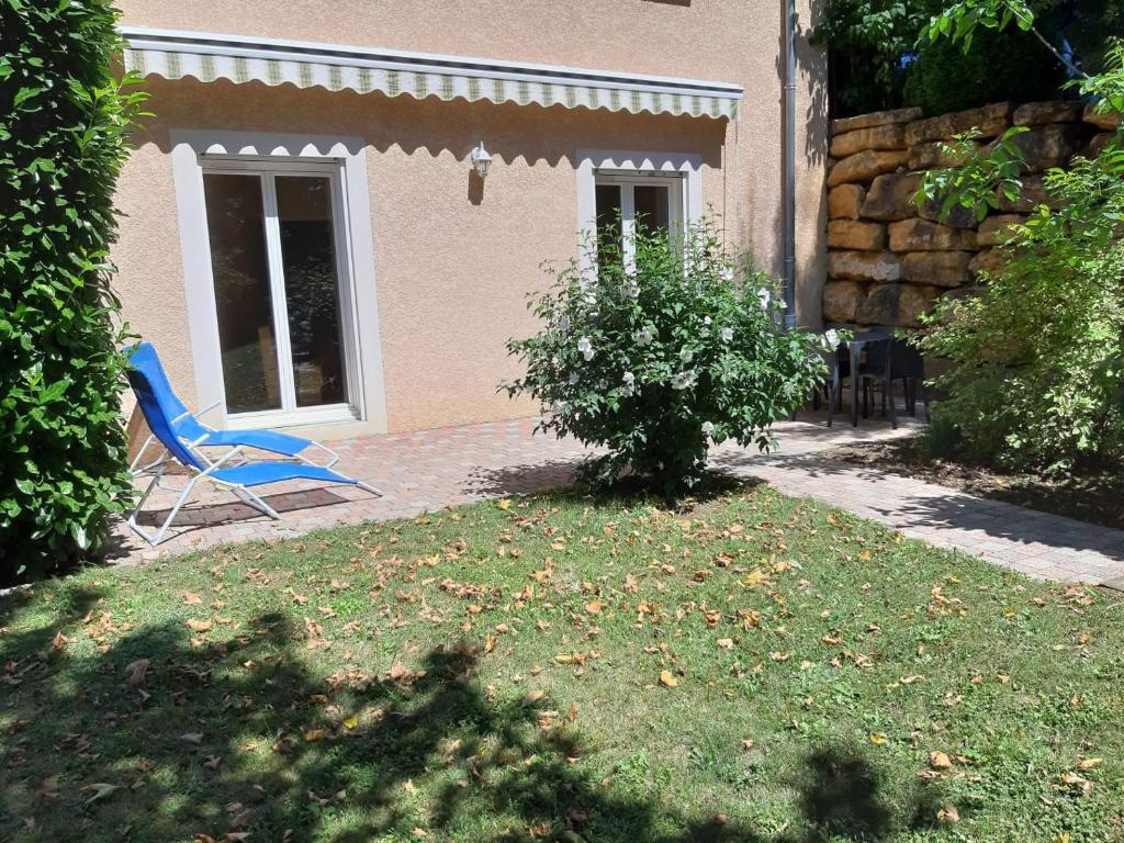 uma cadeira azul sentada num quintal ao lado de uma casa em Appartement dans propriété calme en pleine nature em Charbonnières-les-Bains