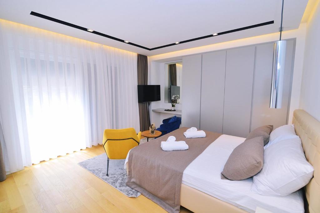 sypialnia z łóżkiem i żółtym krzesłem w obiekcie Apartments in Villa Ziza, rooftop swimming pool w mieście Opatija