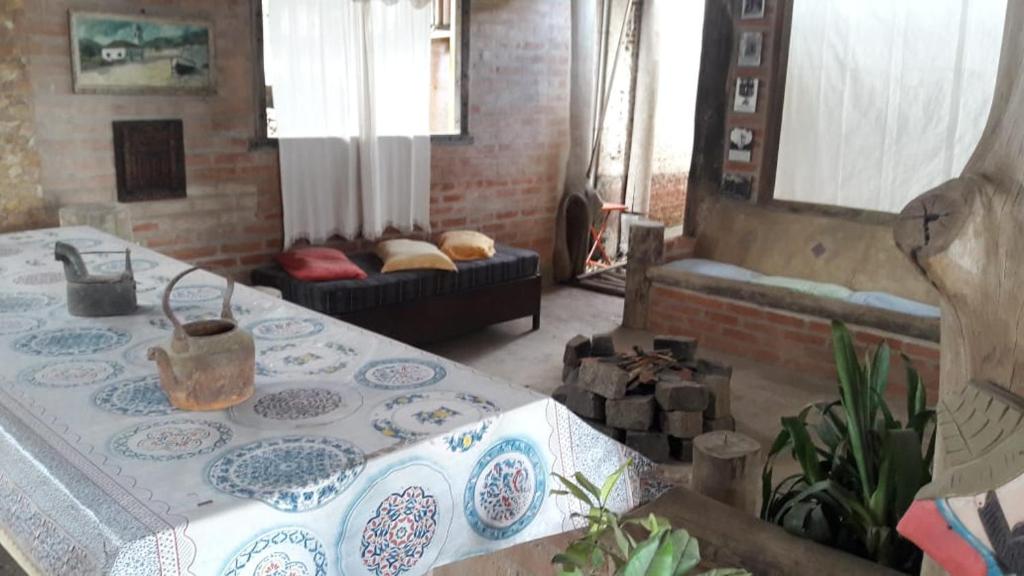 a living room with a table and a couch at A Casinha Pequenina in Monte Verde