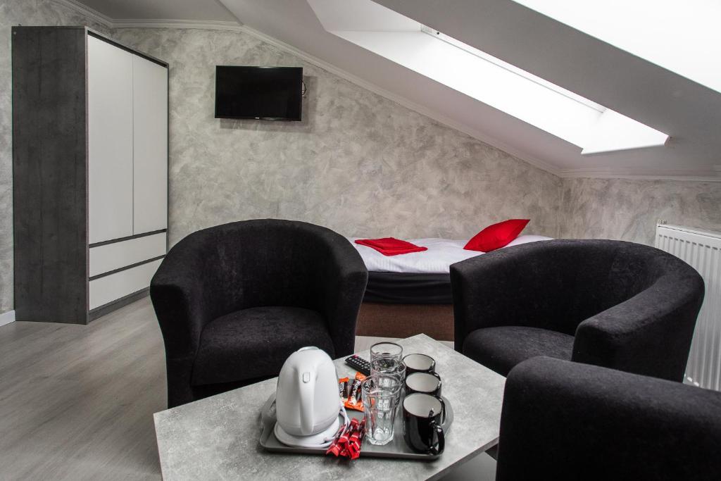 uma sala de estar com duas cadeiras e uma cama em Penzion Bardejov em Bardejov
