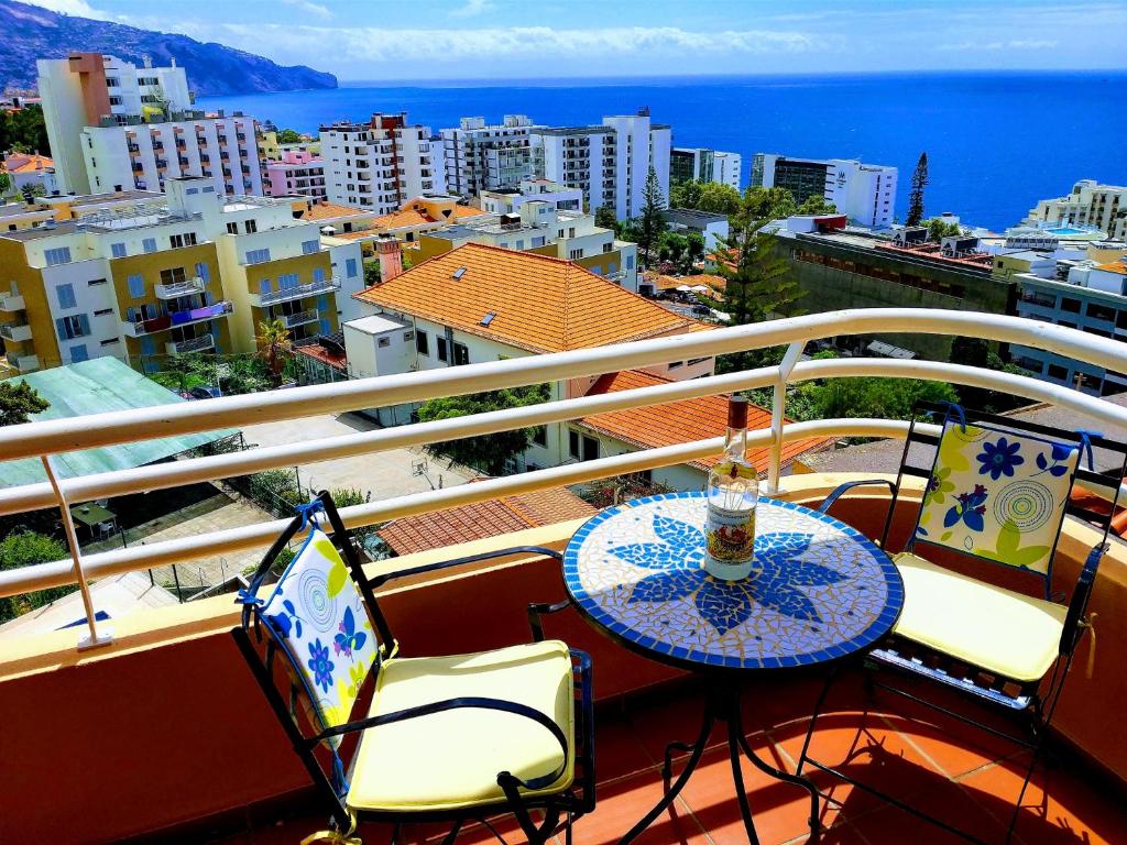een balkon met een tafel en stoelen en de oceaan bij Lido Belissimo in Funchal