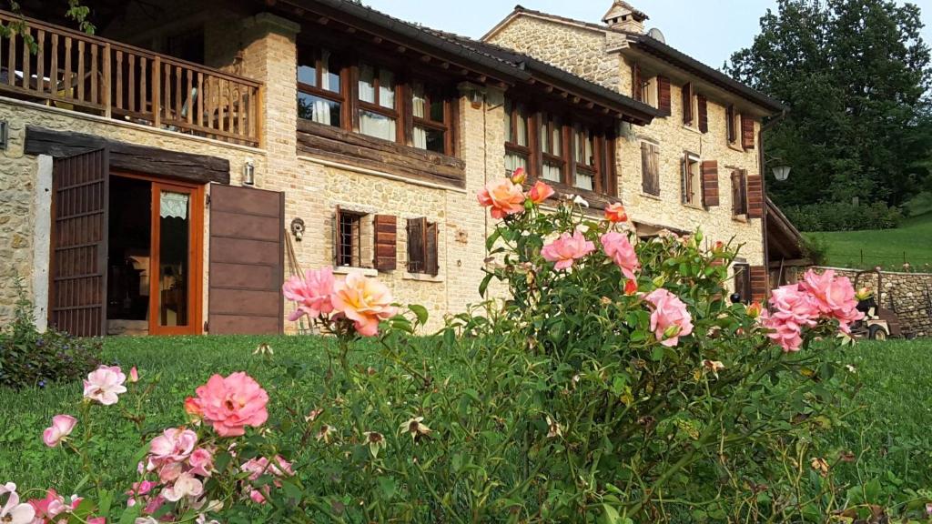 una casa con flores rosas delante de ella en The Music Country House, en Cavaso del Tomba