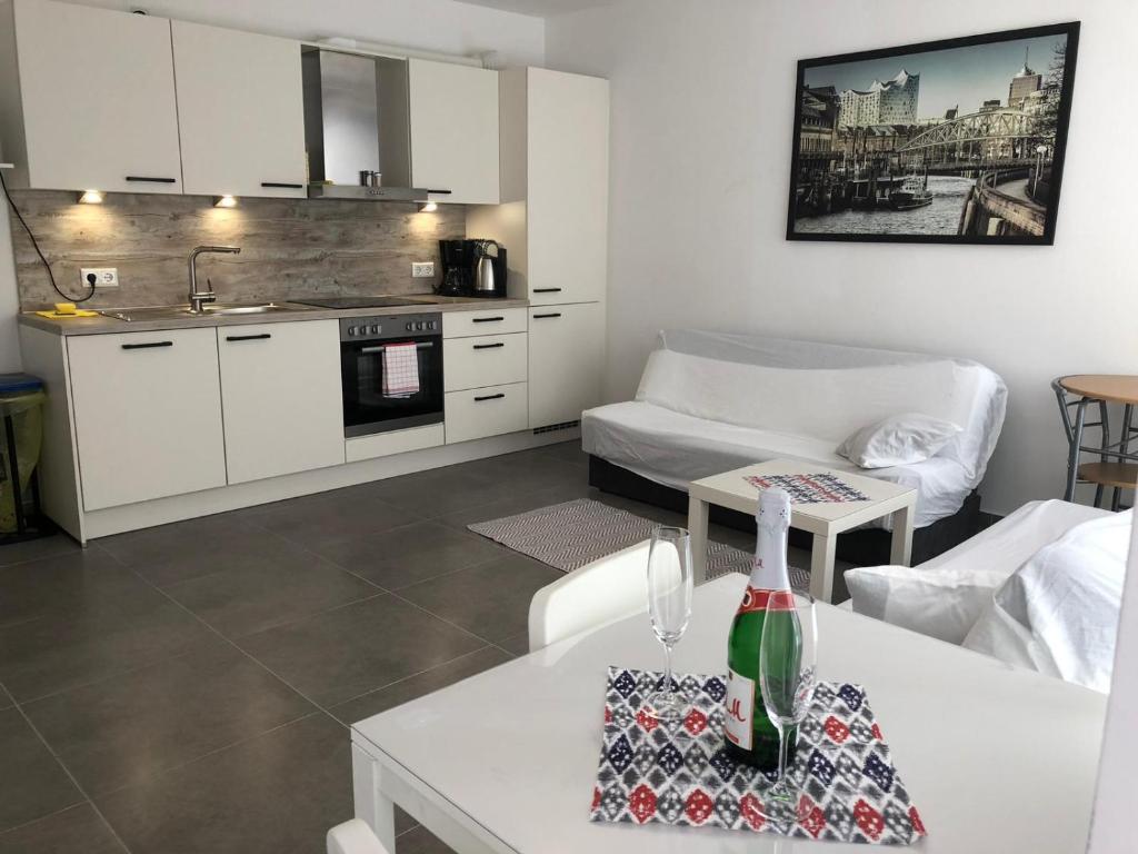 a kitchen and a living room with a table at Apartment EG in Oststeinbek