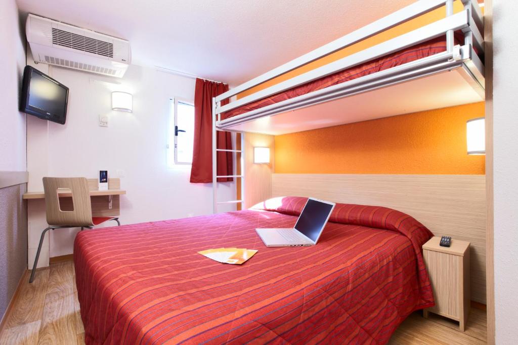 a hotel room with a bed with a laptop on it at Premiere Classe Montreuil in Montreuil