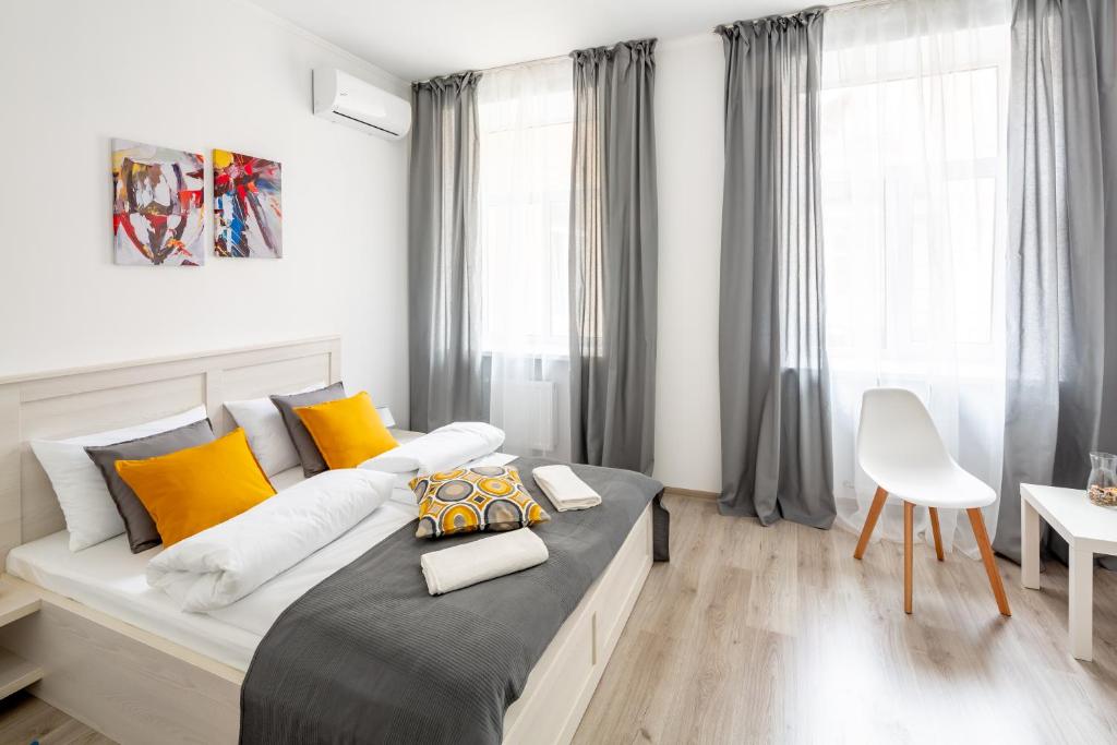 利維夫的住宿－Frederic apartments，一间卧室配有一张大床,提供黄色和橙色枕头