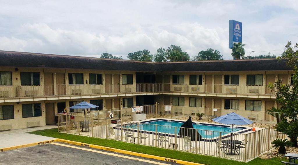 a hotel with a pool and chairs and umbrellas at Americas Best Value Inn - Lake City in Lake City