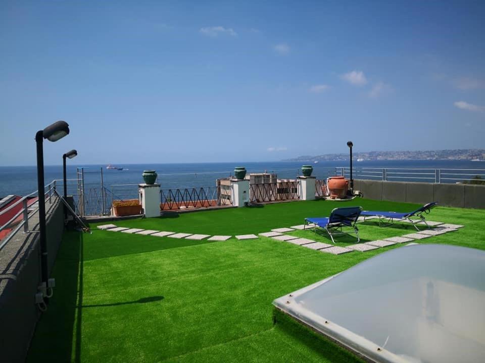 uma casa com um relvado verde e uma piscina em Attico Blu em Nápoles