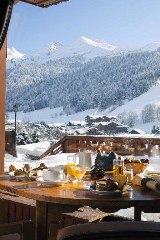 a table with food and drinks on top of a mountain at Carlina in La Clusaz