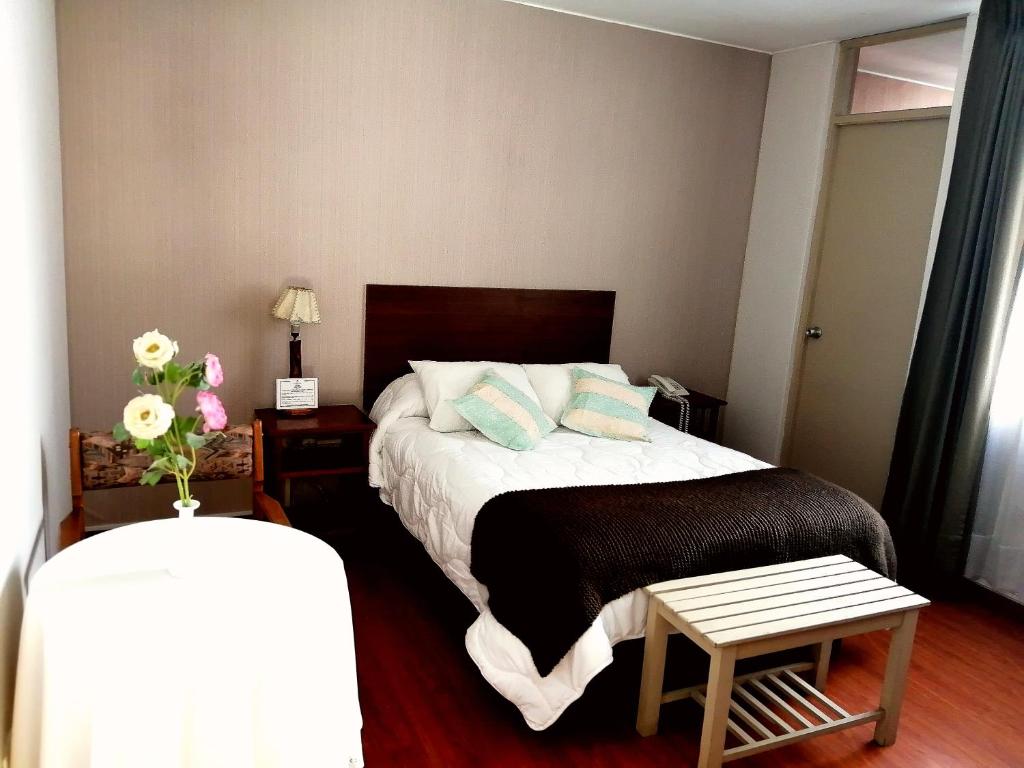 Dormitorio pequeño con cama y mesa en Helena de Santa María, en Arequipa