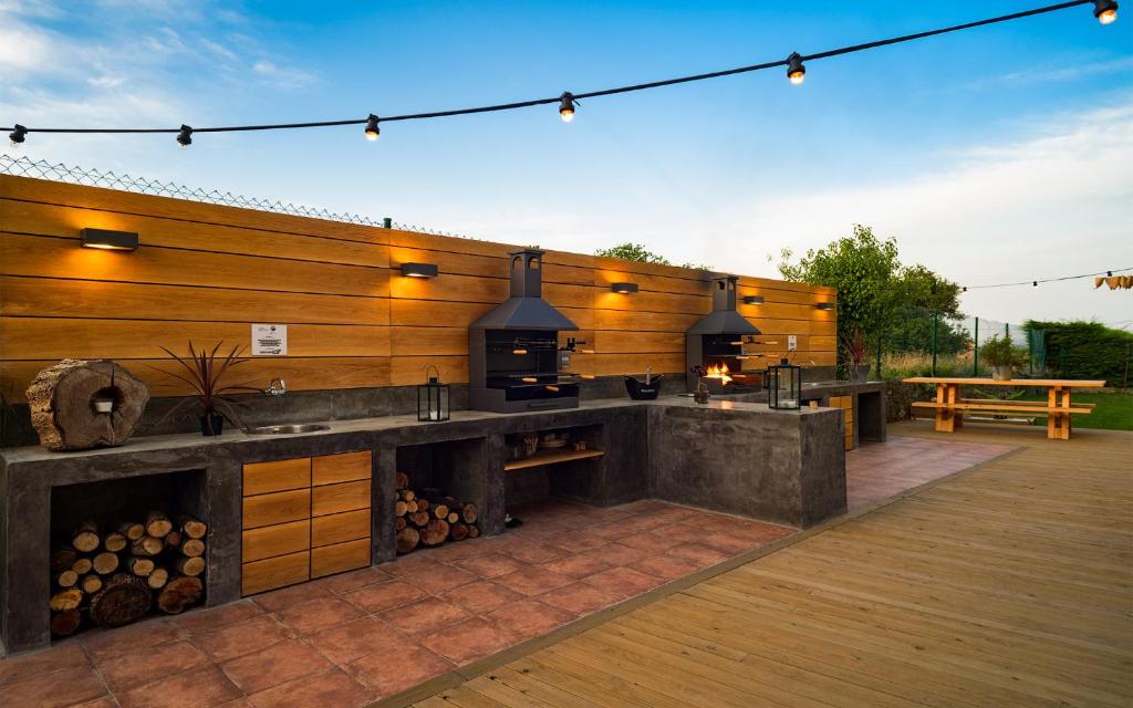 uma cozinha exterior com um balcão e uma parede de madeira em Las Casitas de Santillana em Santillana del Mar