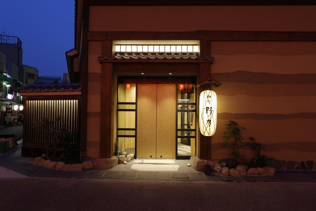 una puerta delantera de un edificio con un reloj en él en Onyado Nono Asakusa Natural Hot Spring en Tokio