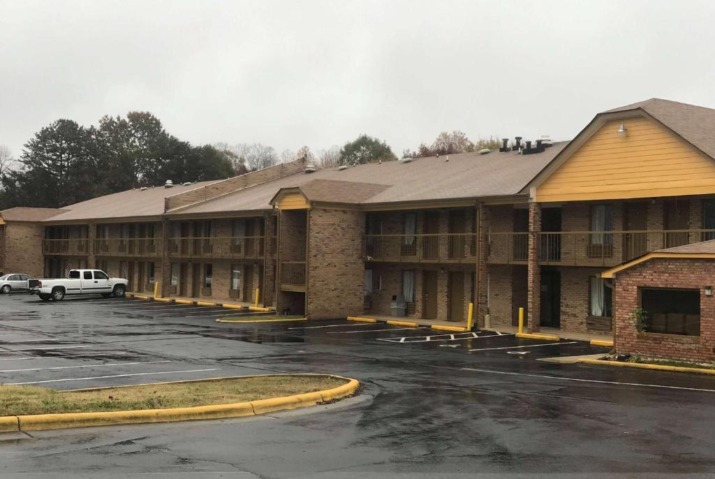 a hotel parking lot with cars parked in front of it at Days Inn by Wyndham King-Winston Salem Area in King
