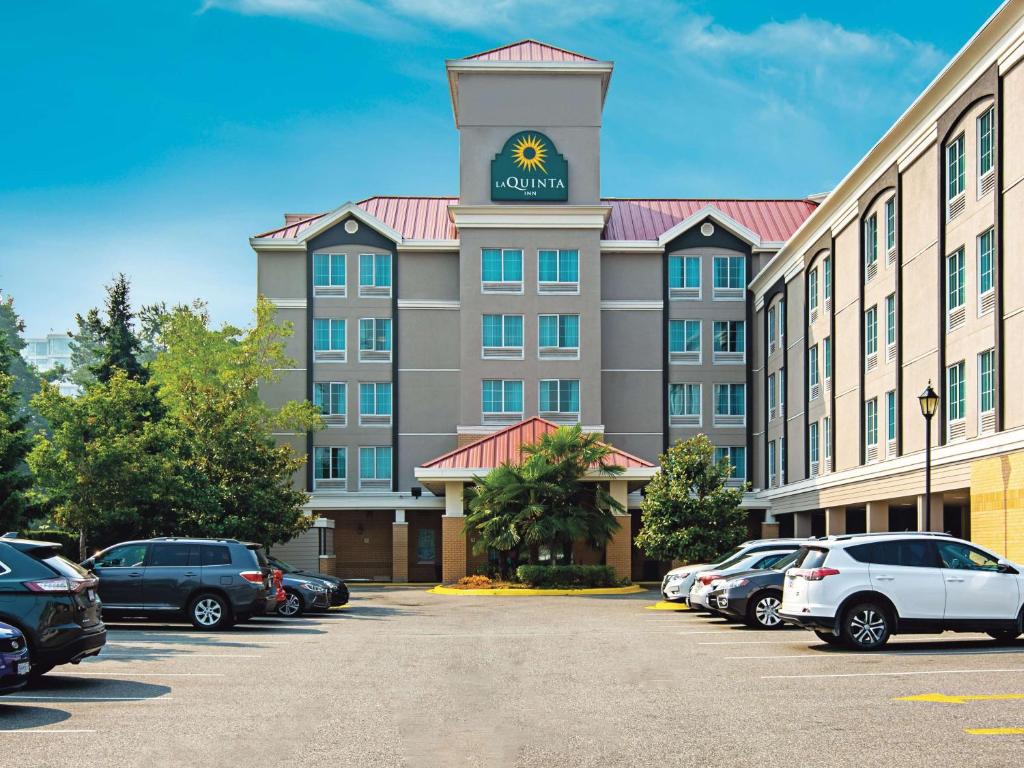 a hotel with a clock tower on top of a parking lot at La Quinta Inn by Wyndham Vancouver Airport in Richmond