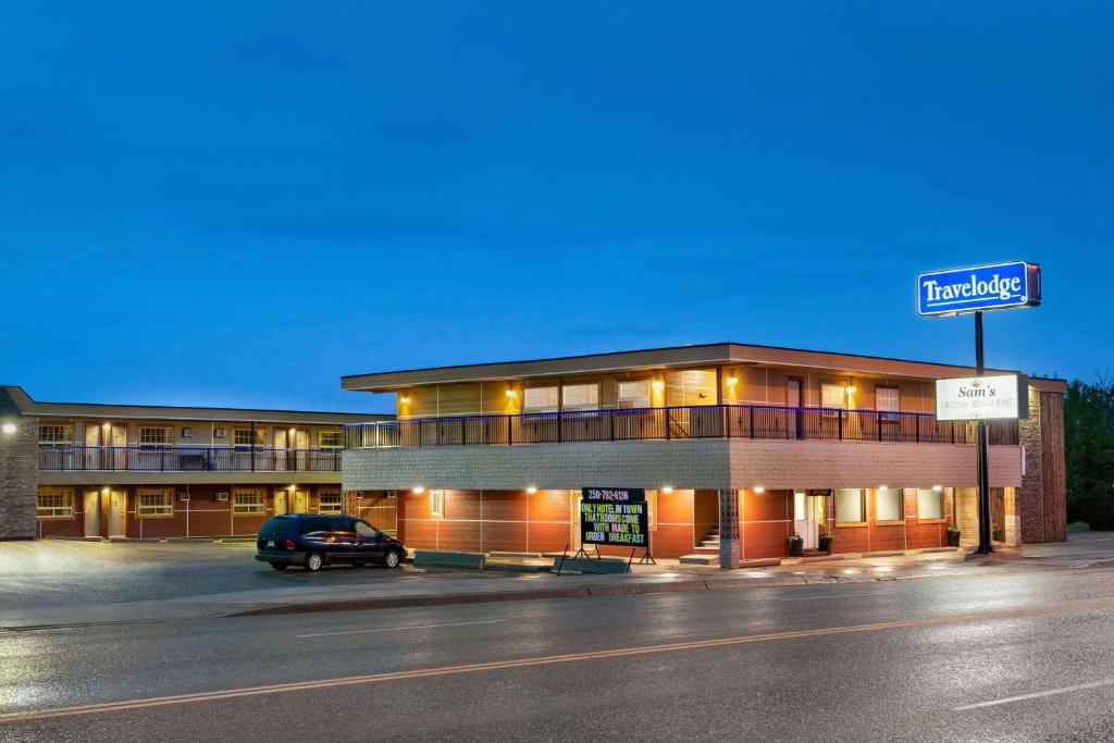 a building with a car parked in front of it at Travelodge by Wyndham Dawson Creek in Dawson Creek