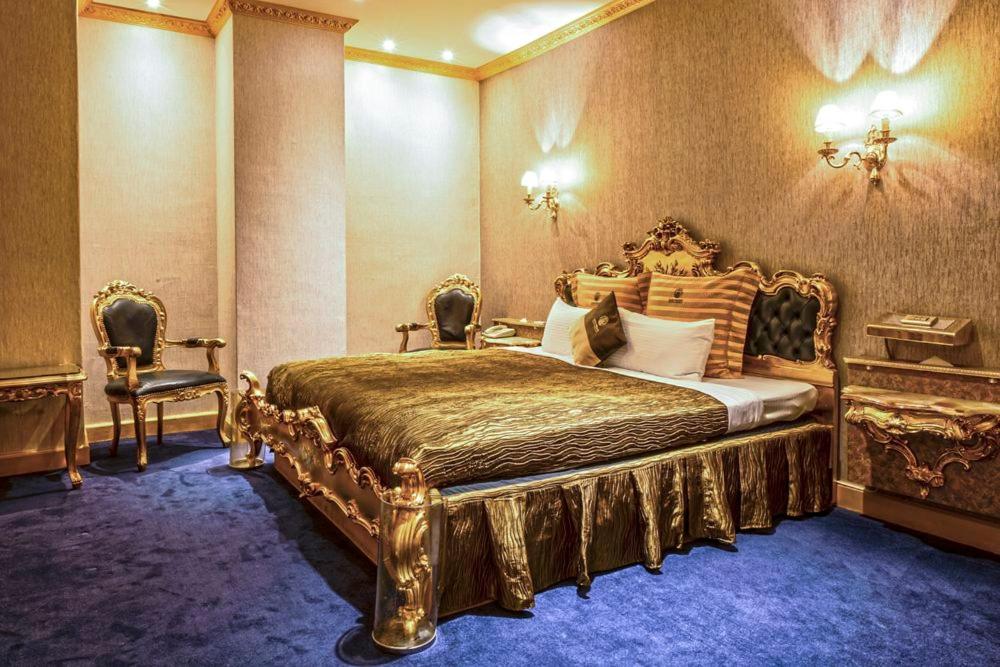 1 Schlafzimmer mit einem Goldbett und 2 Stühlen in der Unterkunft The We Hotel in Taipeh