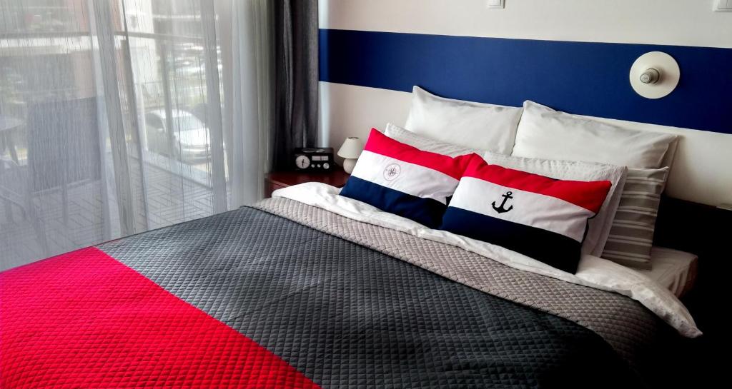 sypialnia z łóżkiem w kolorze czerwono-białym i niebieskim w obiekcie Apartament Baltic Park Plaża 1.1.1 w Świnoujściu