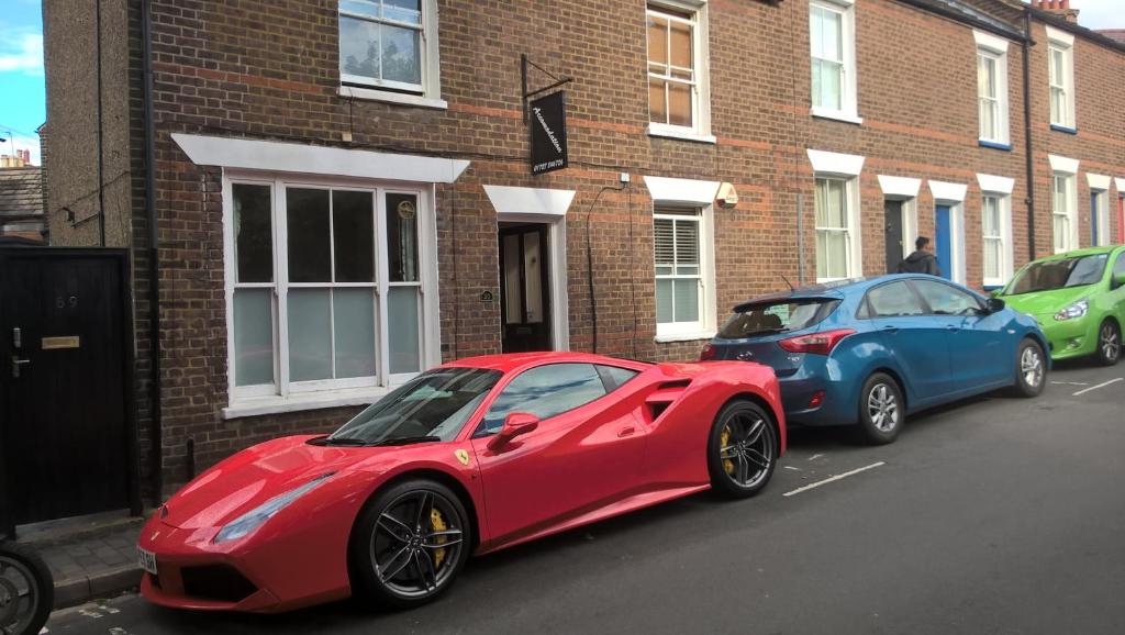 two cars parked in front of a brick building at KEYFIELD TERRACE SERVICED APARTMENTS in Saint Albans